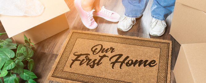 Our first home welcome mat man and woman stood behind