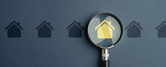 Magnifying glass focusing on a highlighted house icon, symbolising local property search, residential real estate listings, home buying, and property market research.